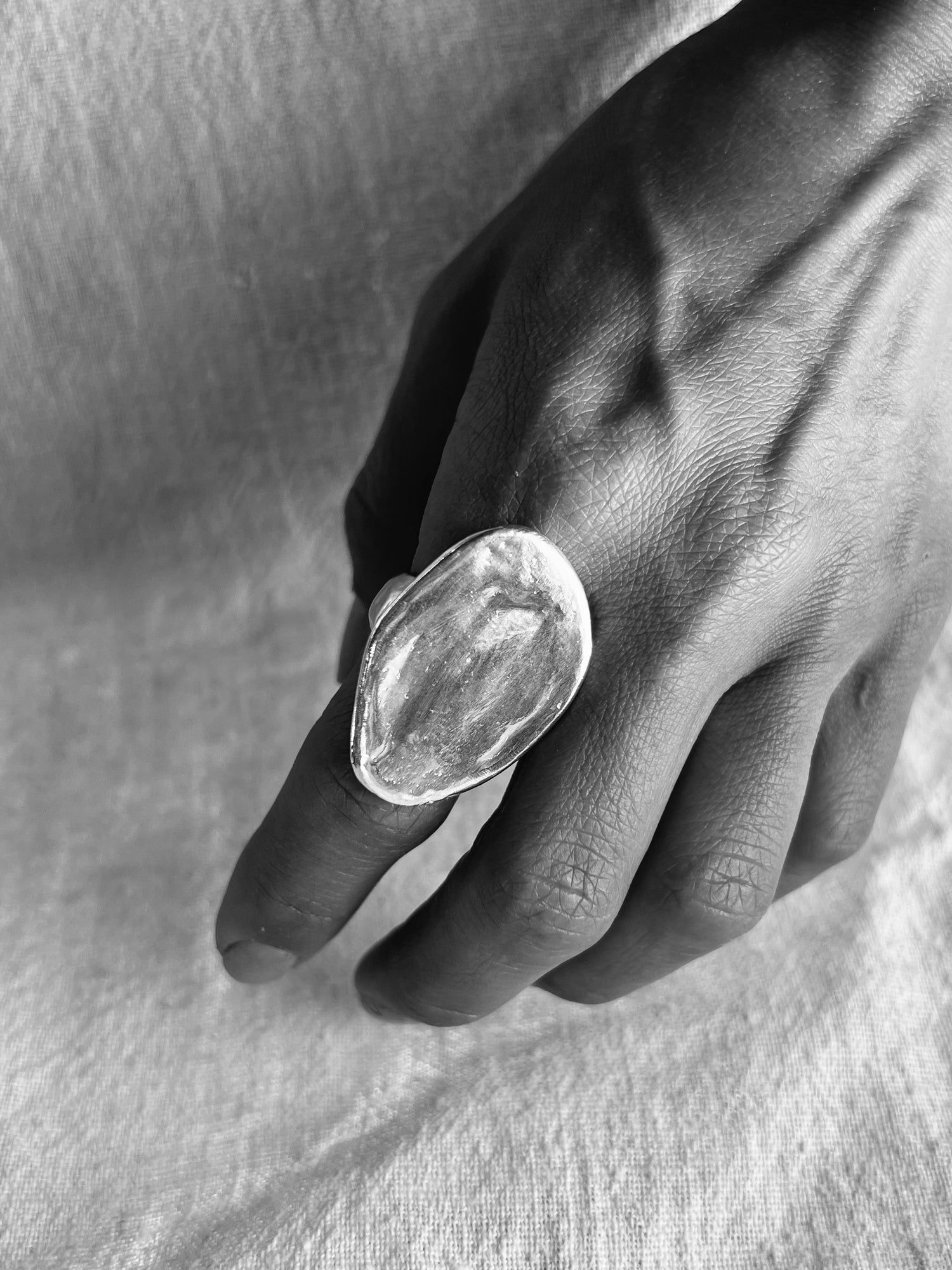 Black and white photo of hand model with Tierra silver ring. Ring is sculpted in lost was cast techniques.