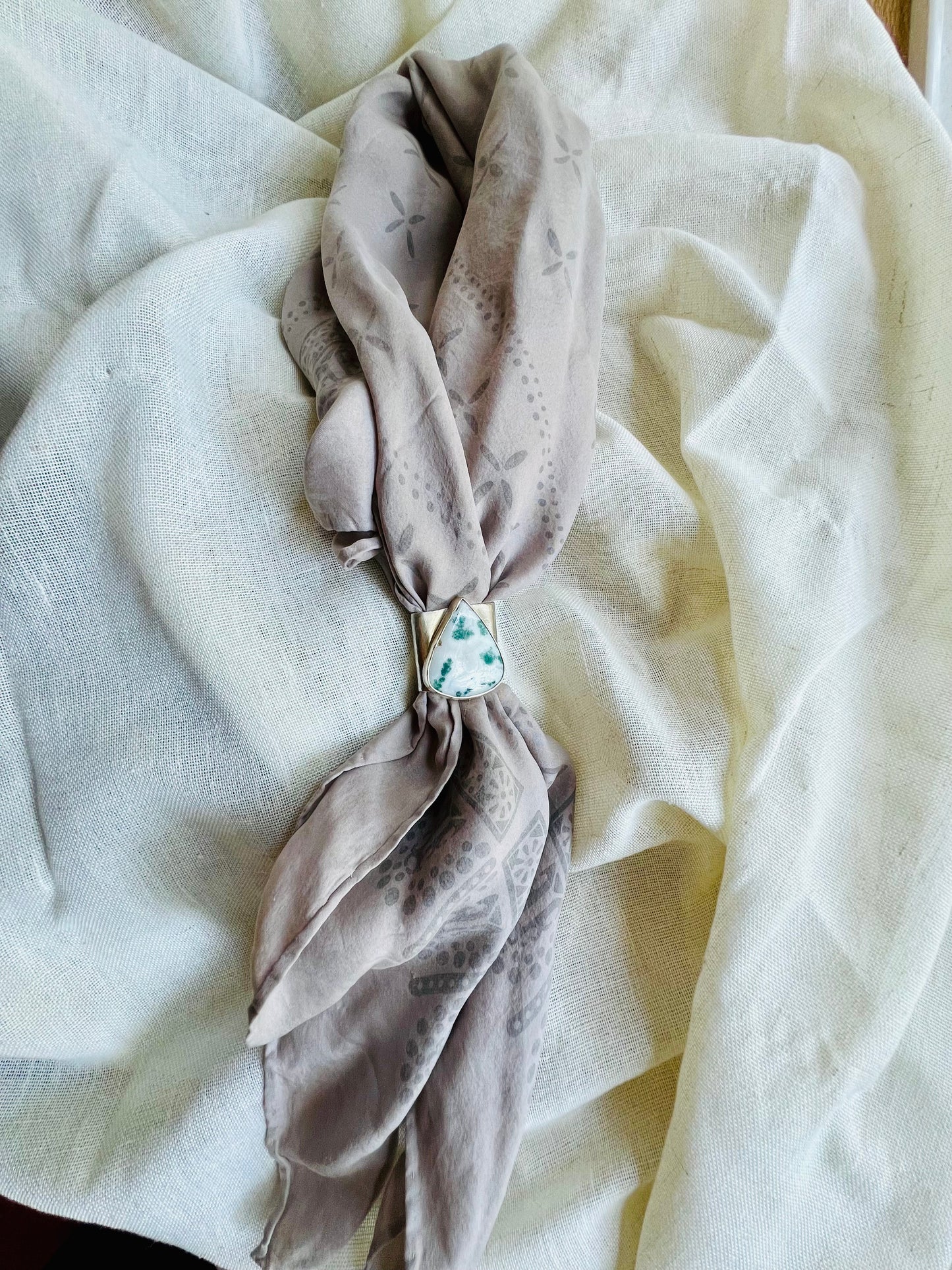 Wild rag bronze bandana slide with tree agate stone. Displayed on silk ozma bandana.