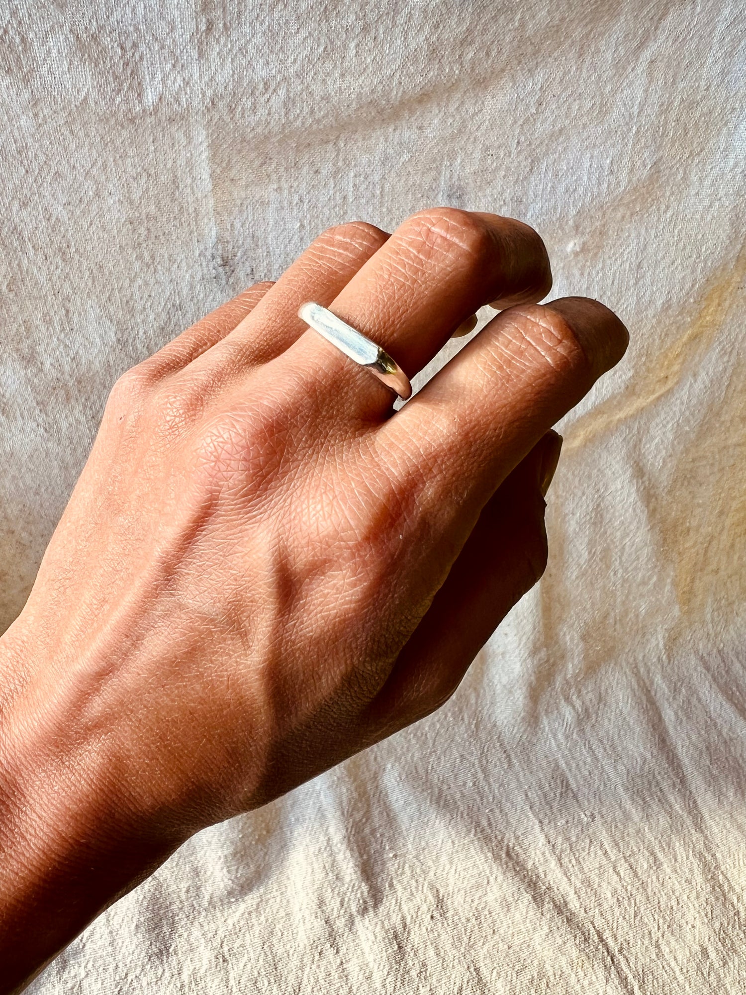 Hand model with sculpted signet ring made in silver. Lost wax cast ring