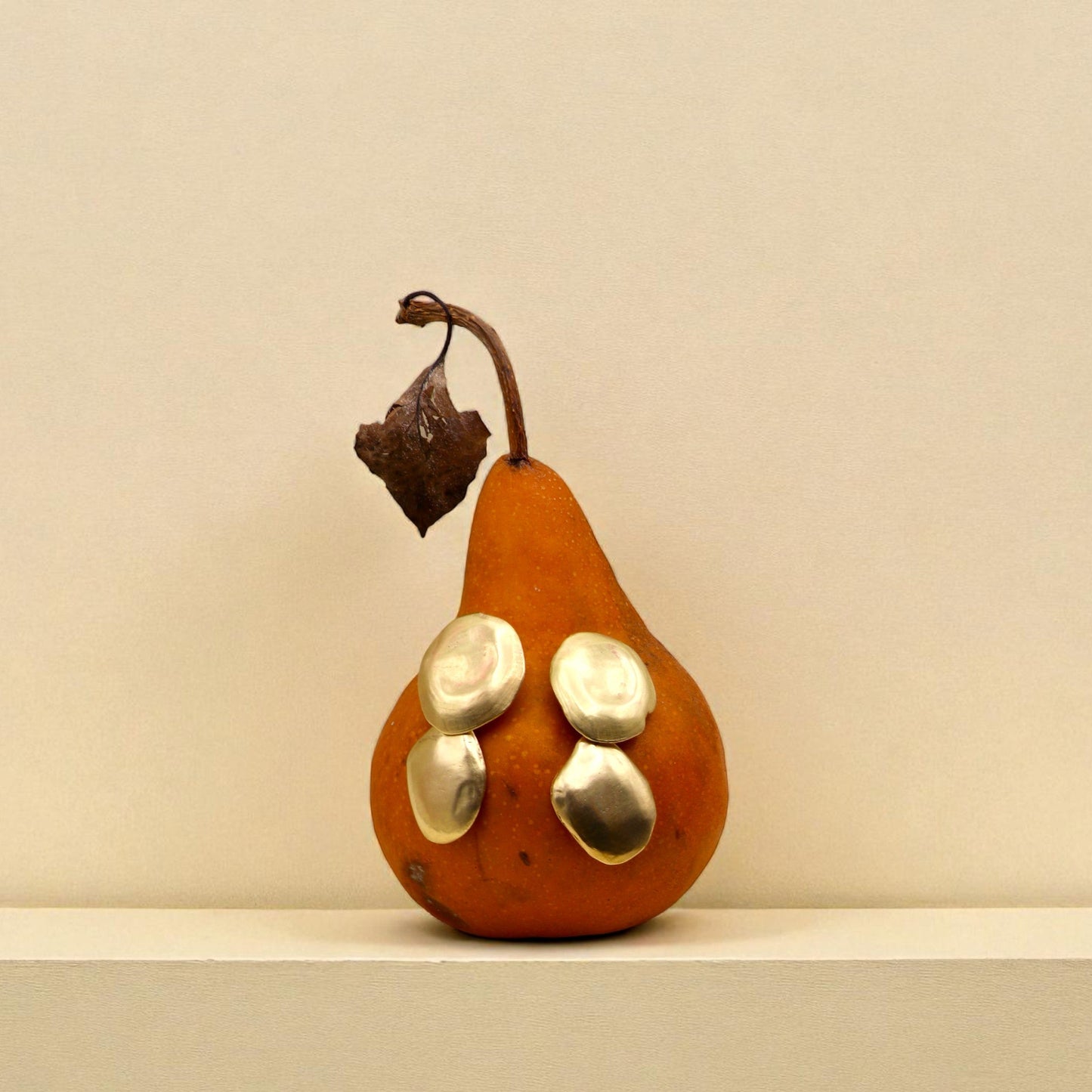 Brass earrings displayed on pear