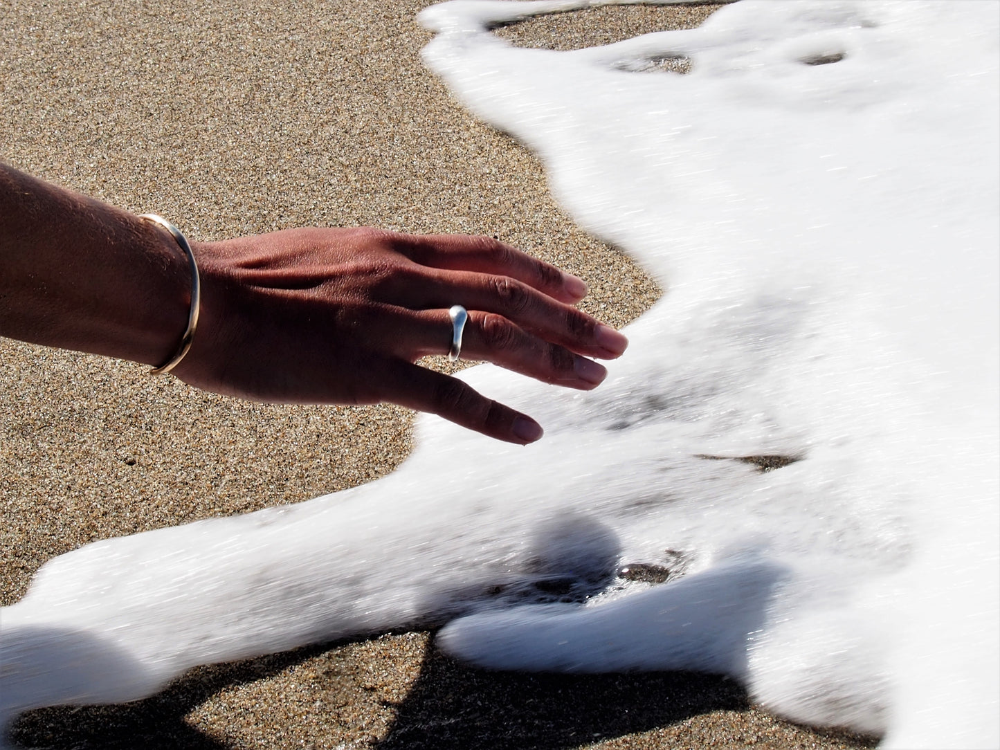 Handcrafted sculpted ring, meticulously carved using the lost wax casting technique and crafted from recycled silver. Created by Soulfull Studio. Jewelry for the wild ones. Hand model at beach in ocean.