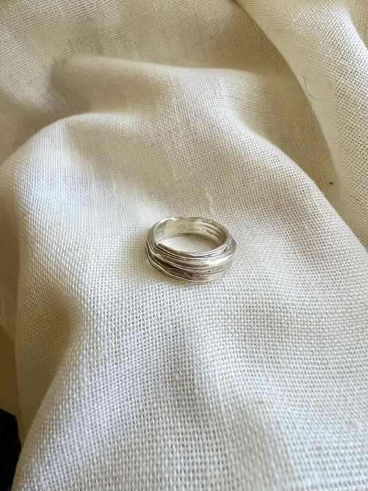 Mitsuro hikime ring on cream linen background. Handmade by Soul Full Studio.