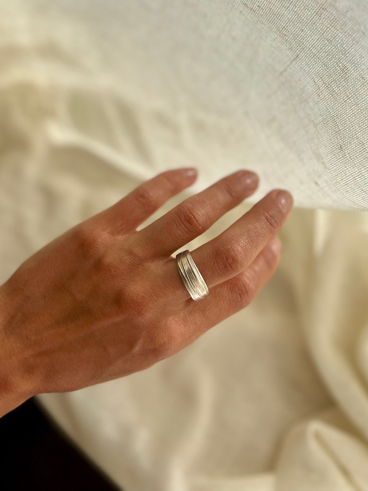 Mitsuro hikime ring on cream linen background. Handmade by Soul Full Studio.