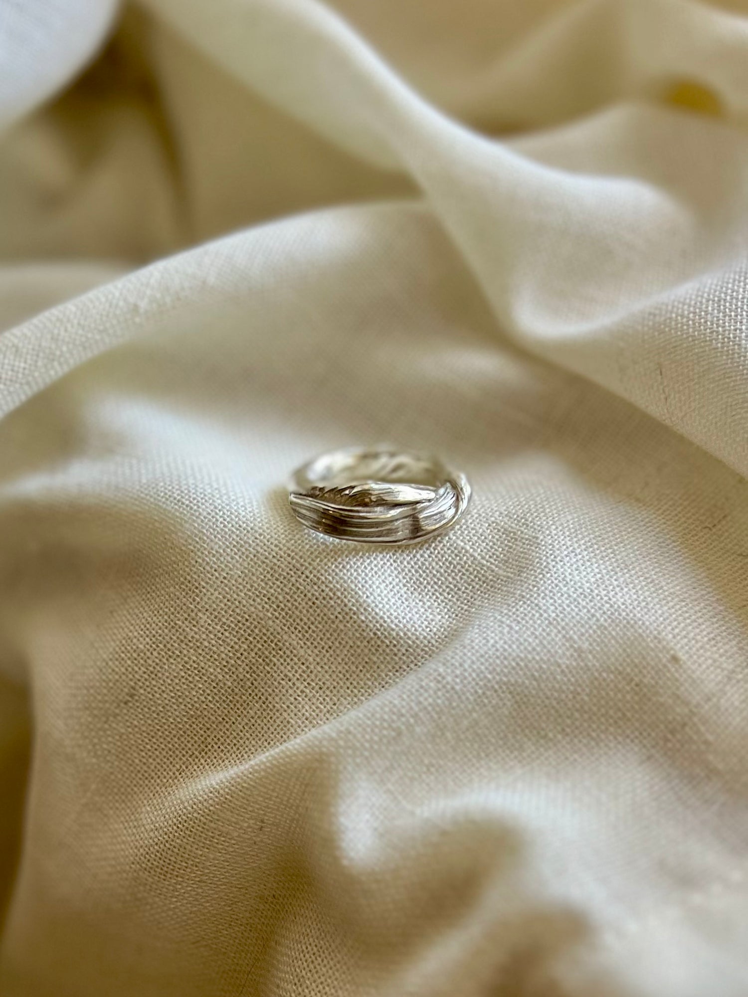 Mitsuro hikime ring on cream linen background. Handmade by Soul Full Studio.