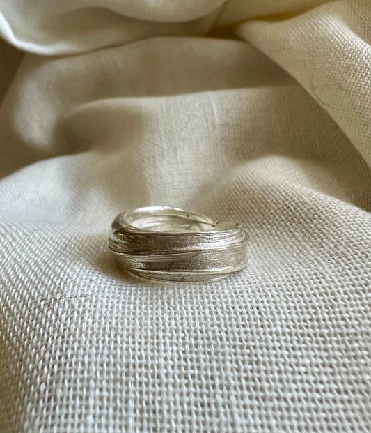 Mitsuro hikime ring on cream linen background. Handmade by Soul Full Studio.