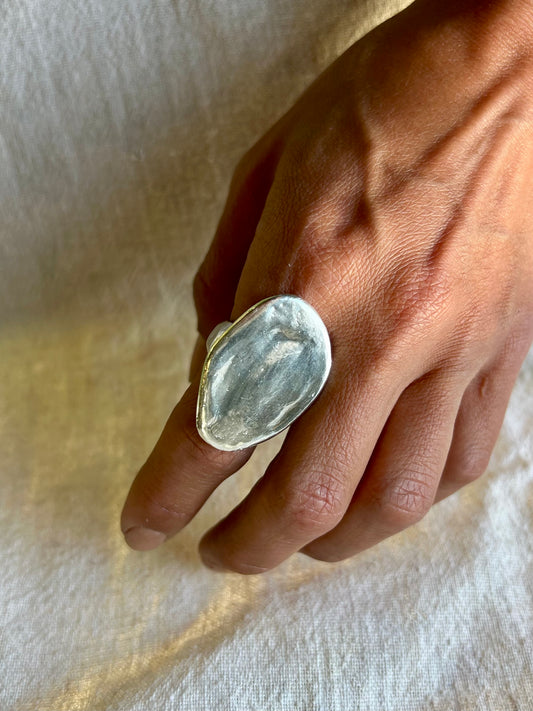 Hand model with sculpted silver ring. Silver ring displayed on white background. silver ring with sculpted organic design and texture. Ring is designed by soul full studio and handmade with lost wax casting and metal smithing techniques. Jewelry inspired by Georgia Okeefe