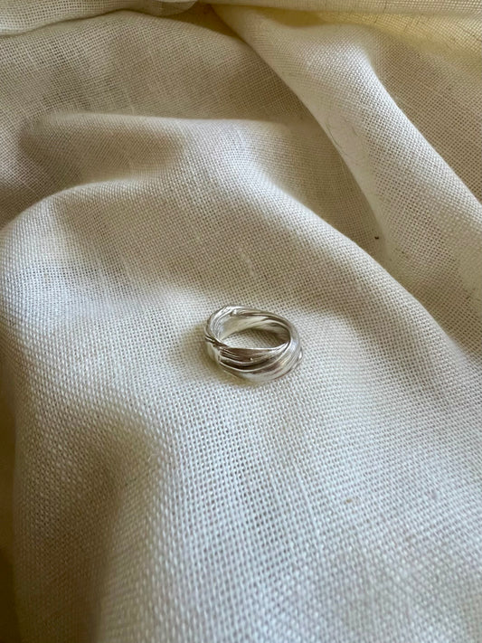 Mitsuro hikime ring on cream linen background. Handmade by Soul Full Studio.