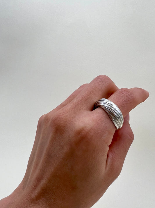Silver sculptural ring crafted using the Mitsuro Hikime technique by Soul Full Studio. Hand model with white background.