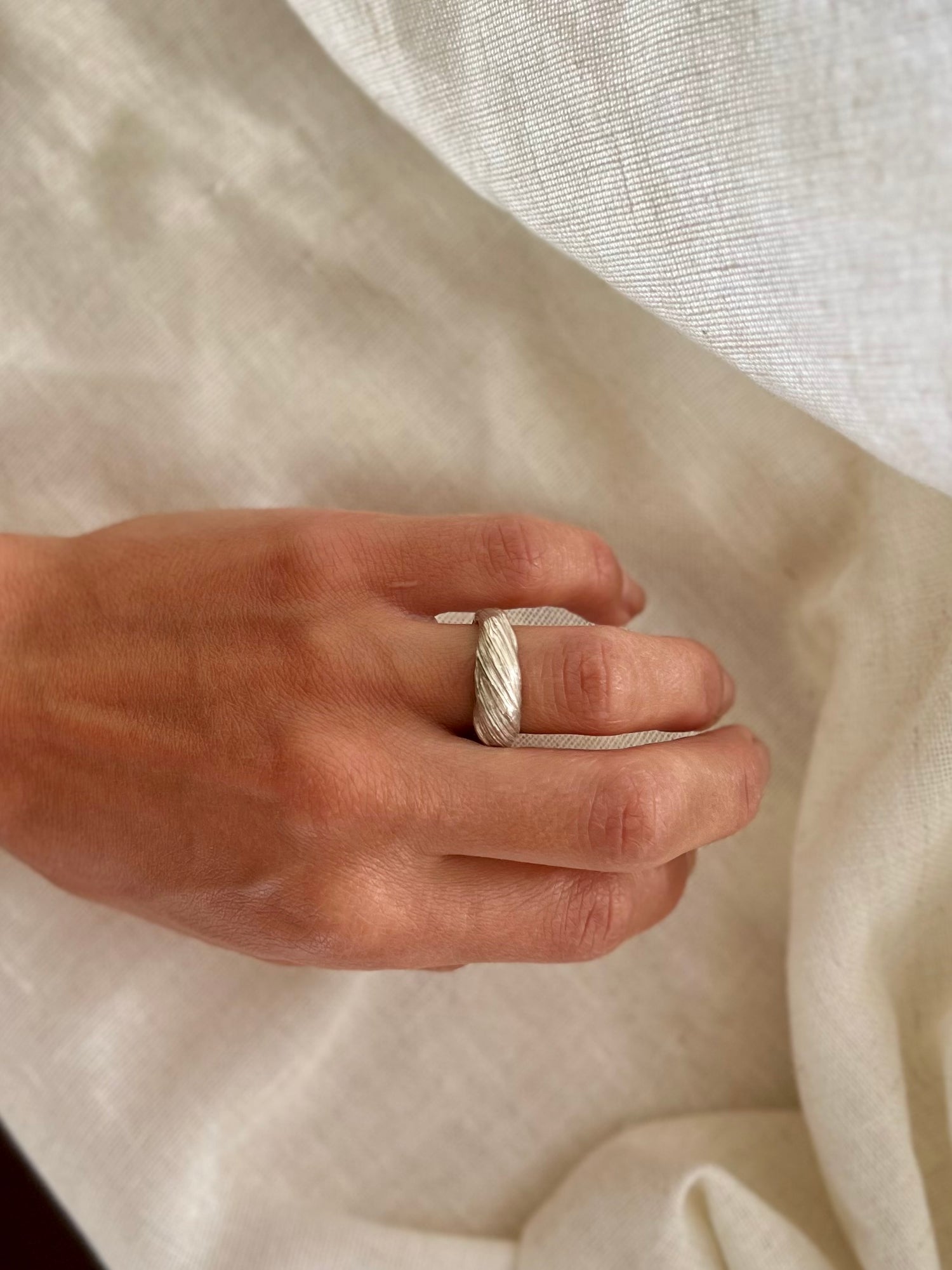 Mitsuro hikime ring on cream linen background. Handmade by Soul Full Studio.