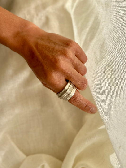 Mitsuro hikime ring on cream linen background. Handmade by Soul Full Studio.