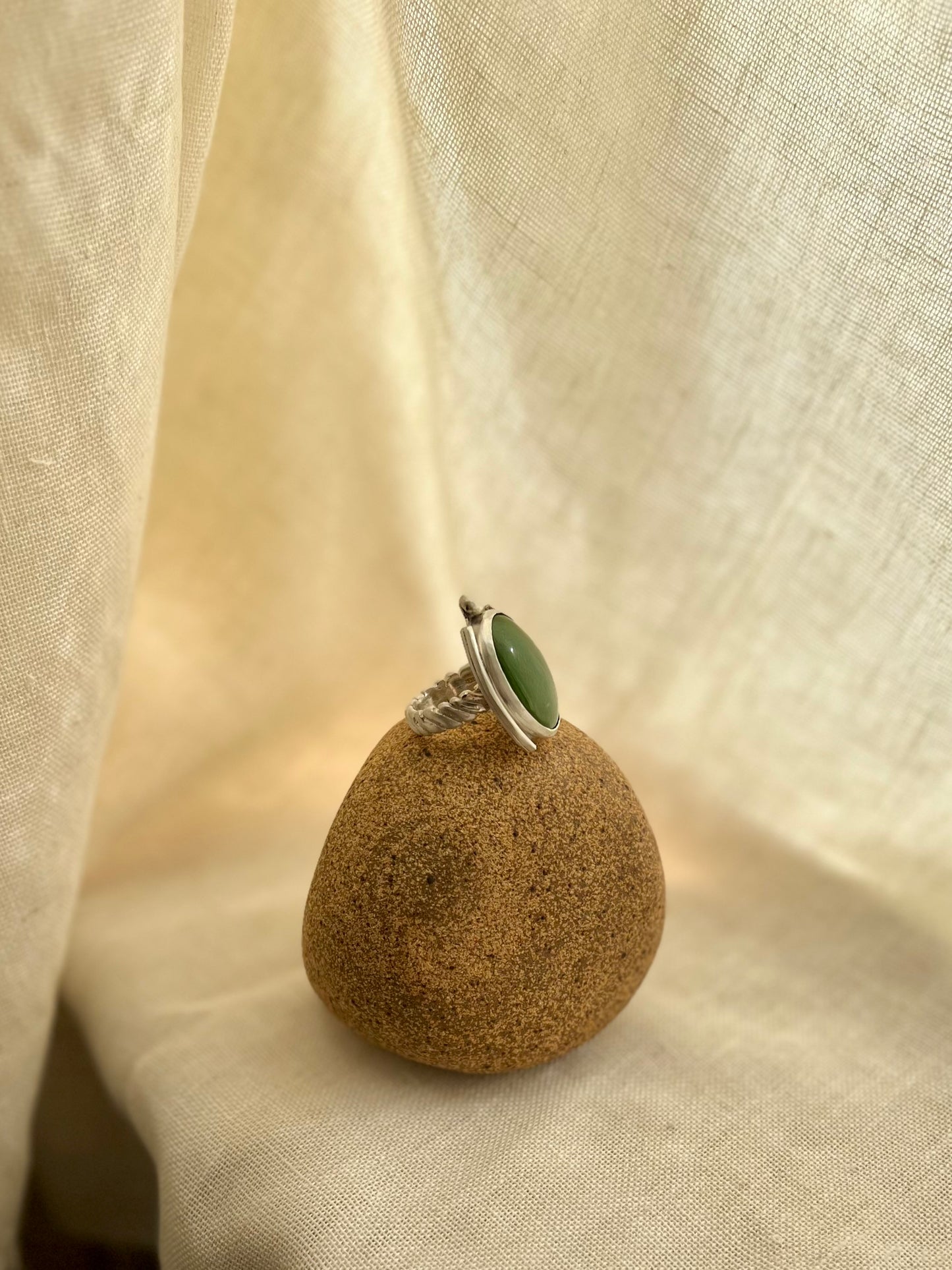 Green chalcedony set in sterling silver. Displayed on rock prop with cream linen background. Handmade from soul full studio using metal smithing techniques. 