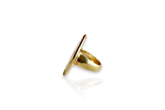 Between earth and sky yellow brass ring. Displayed from the side on white background. 
