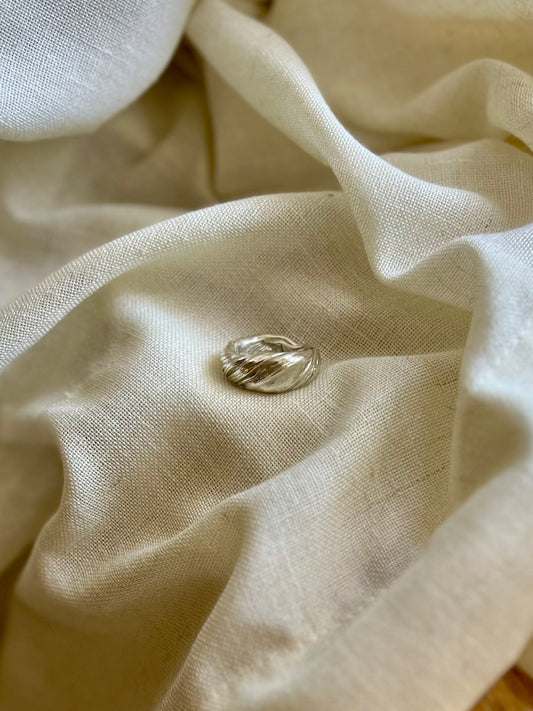 Mitsuro hikime ring on cream linen background. Handmade by Soul Full Studio.