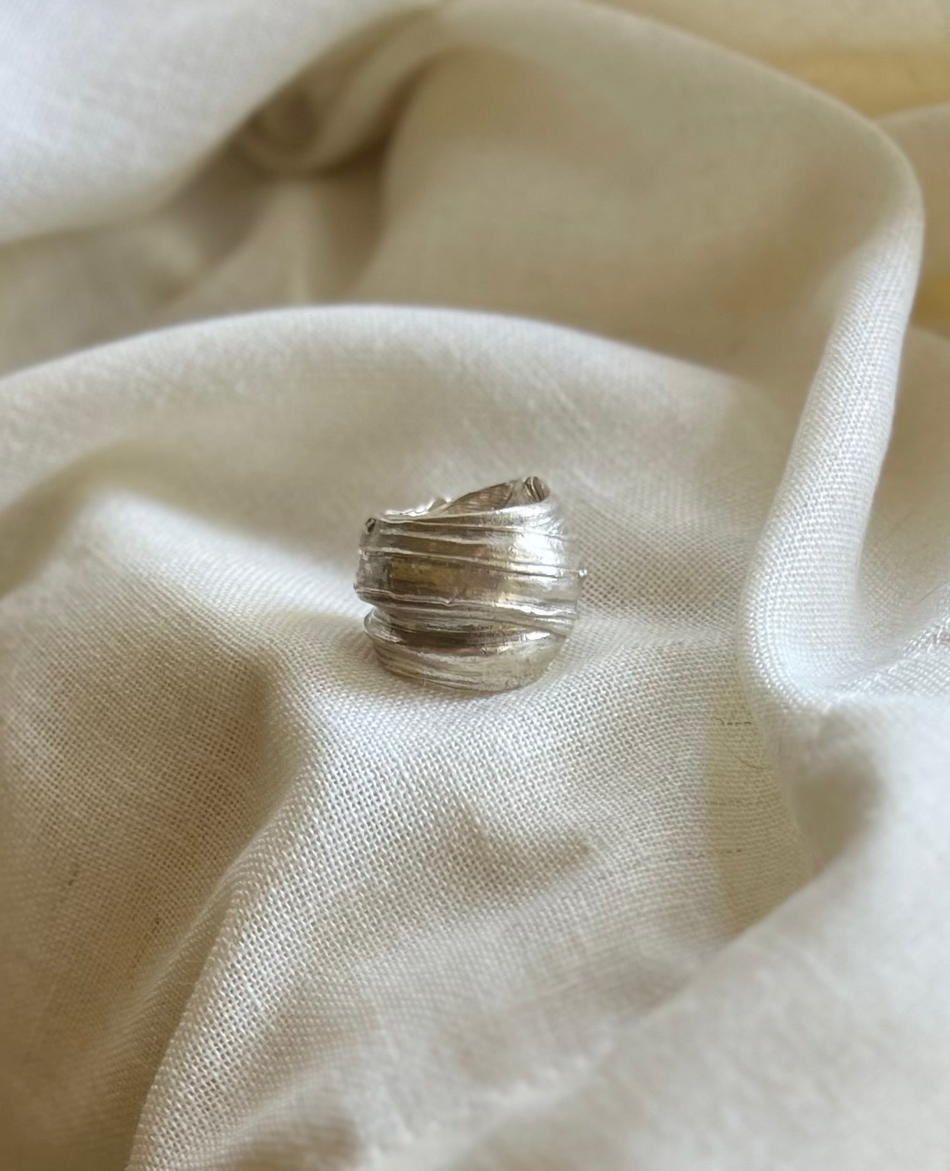 Mitsuro hikime ring on cream linen background. Handmade by Soul Full Studio.