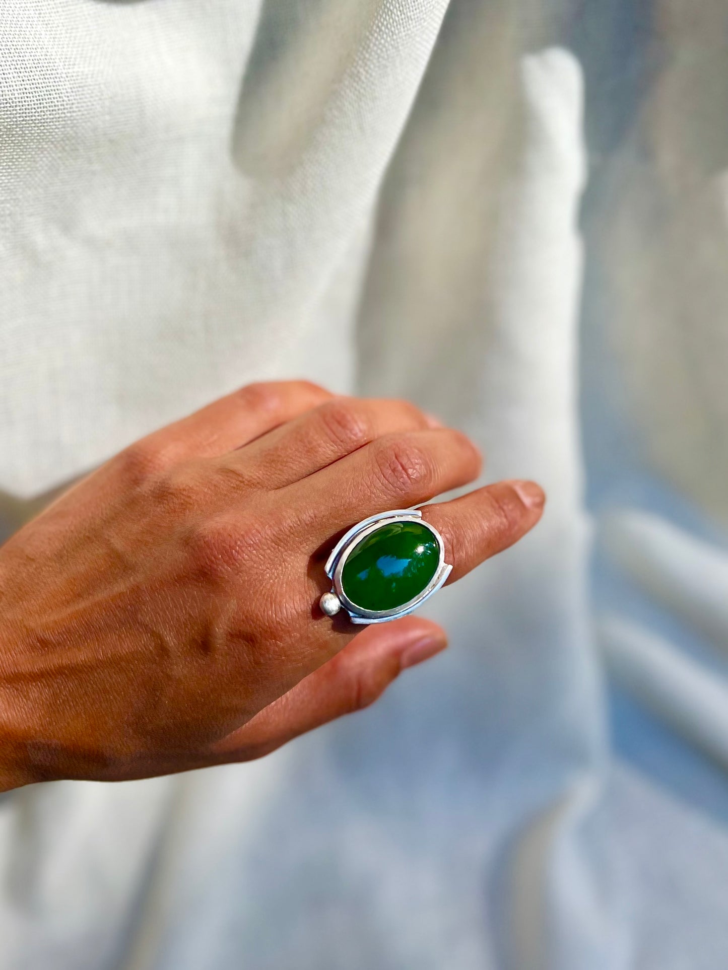 Hand model in green chalcedony set in sterling silver. Displayed on cream linen background. Handmade from soul full studio using metal smithing techniques. 