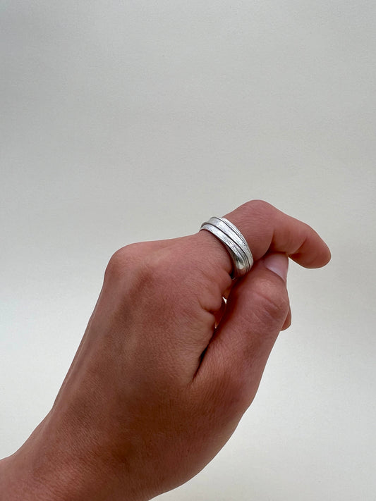 Silver sculptural ring crafted using the Mitsuro Hikime technique by Soul Full Studio. Hand model with white background.