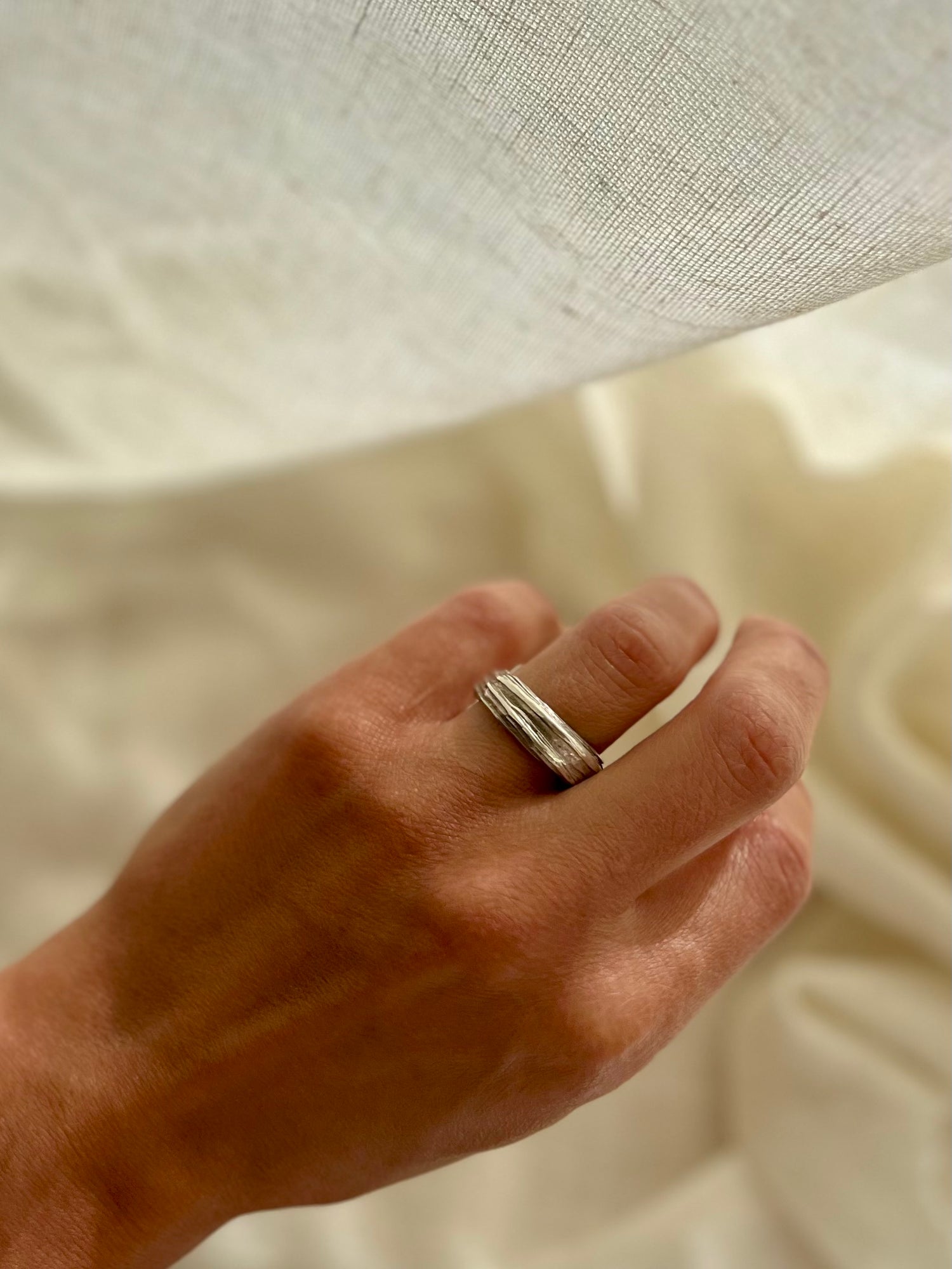 Mitsuro hikime ring on cream linen background. Handmade by Soul Full Studio.