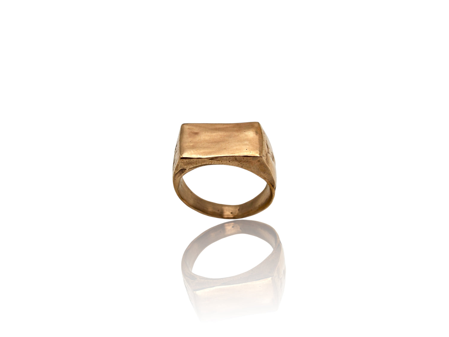 This image displays a yellow brass signet ring with organic, sculpted features. Displayed on white background. 
