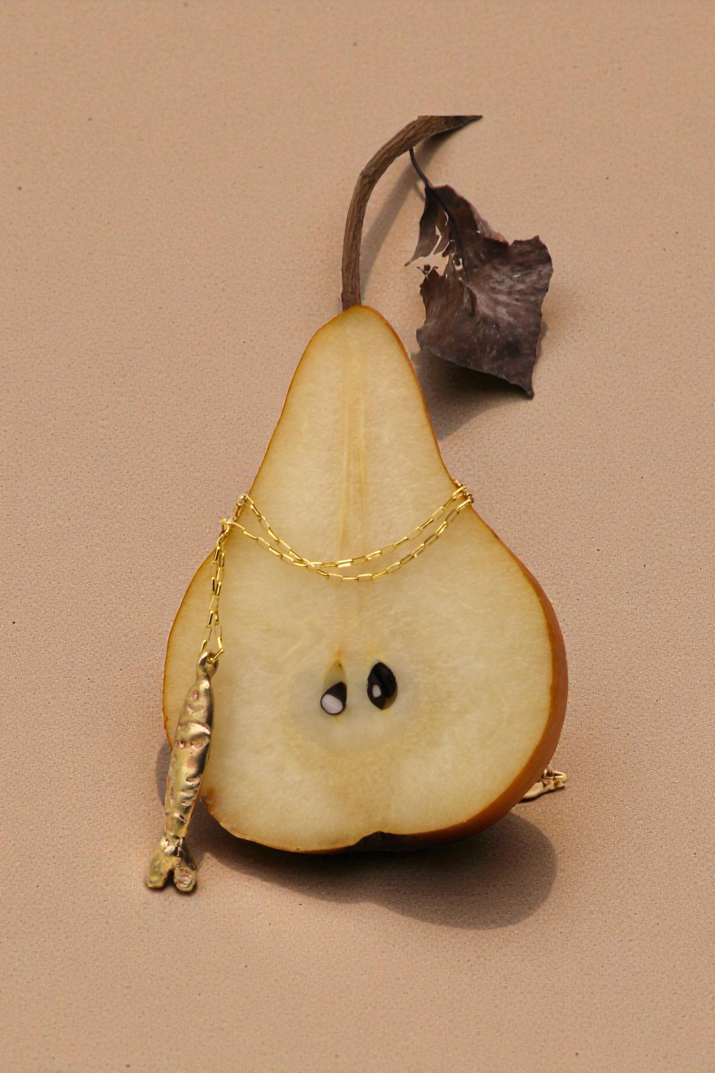 Tinfish necklace displayed on pair with light background. 