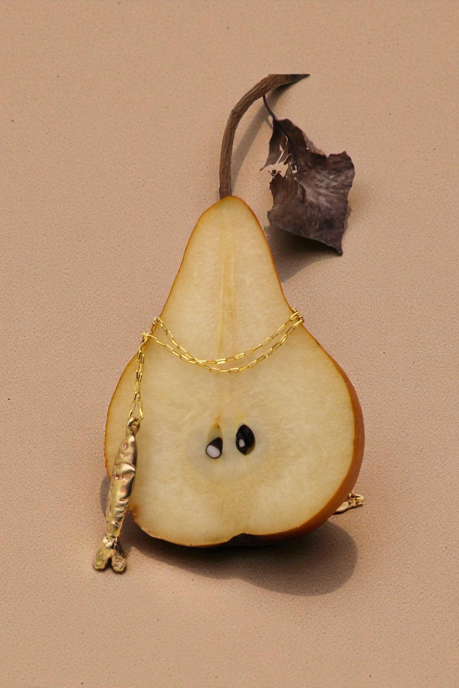 Tinfish necklace displayed on pair with light background. 