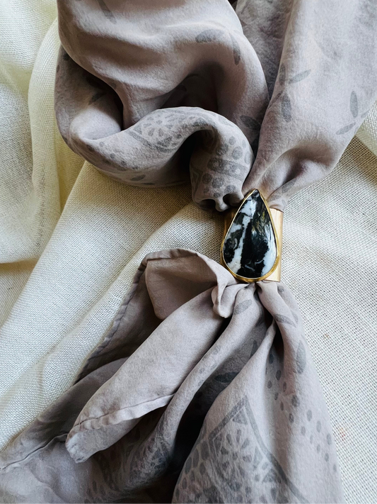 Wild rag brass bandana slide with white buffalo turquoise stone. Displayed on silk Ozma bandana. 